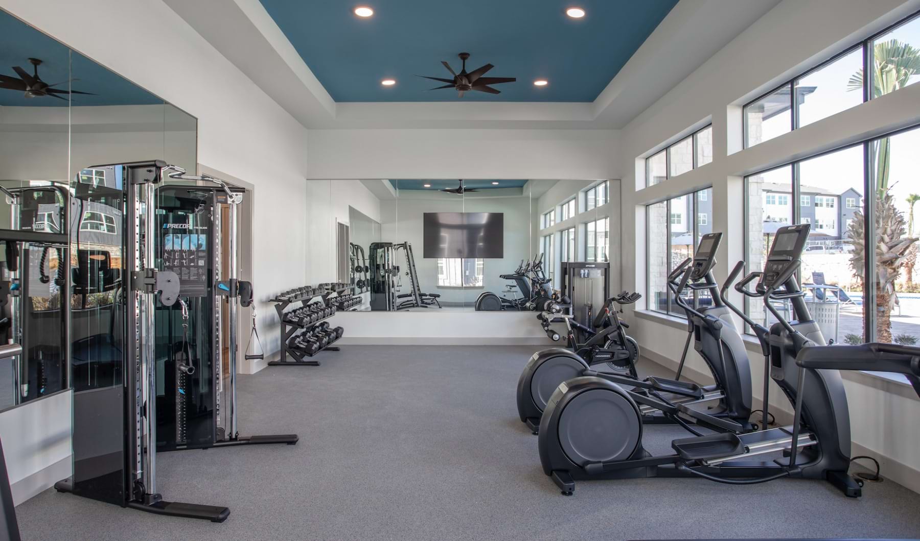 Surround Yourself With The Best apartment community fitness center with ample equipment and large windows